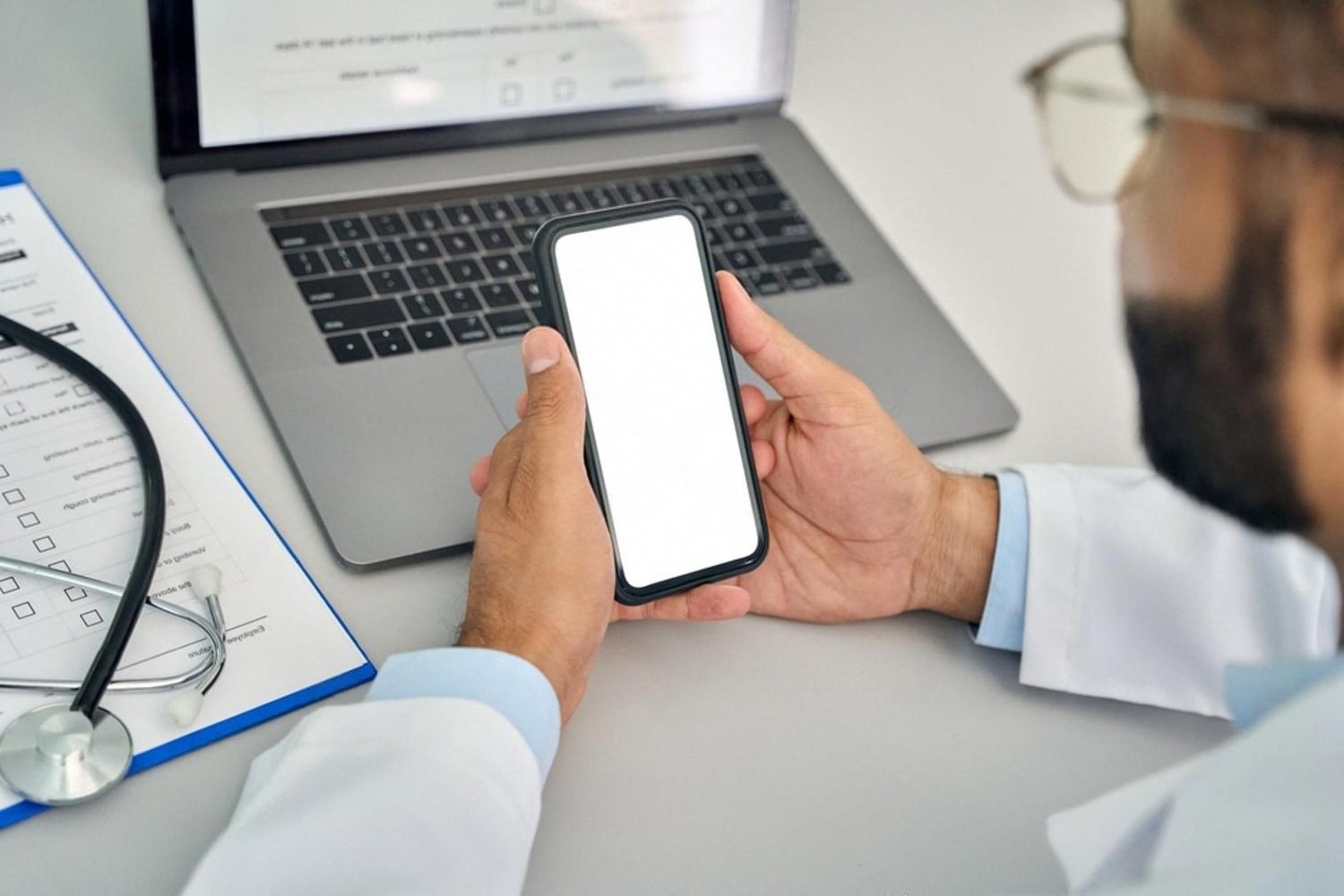 Dubai bariatric specialist reviewing patient records on a phone and laptop