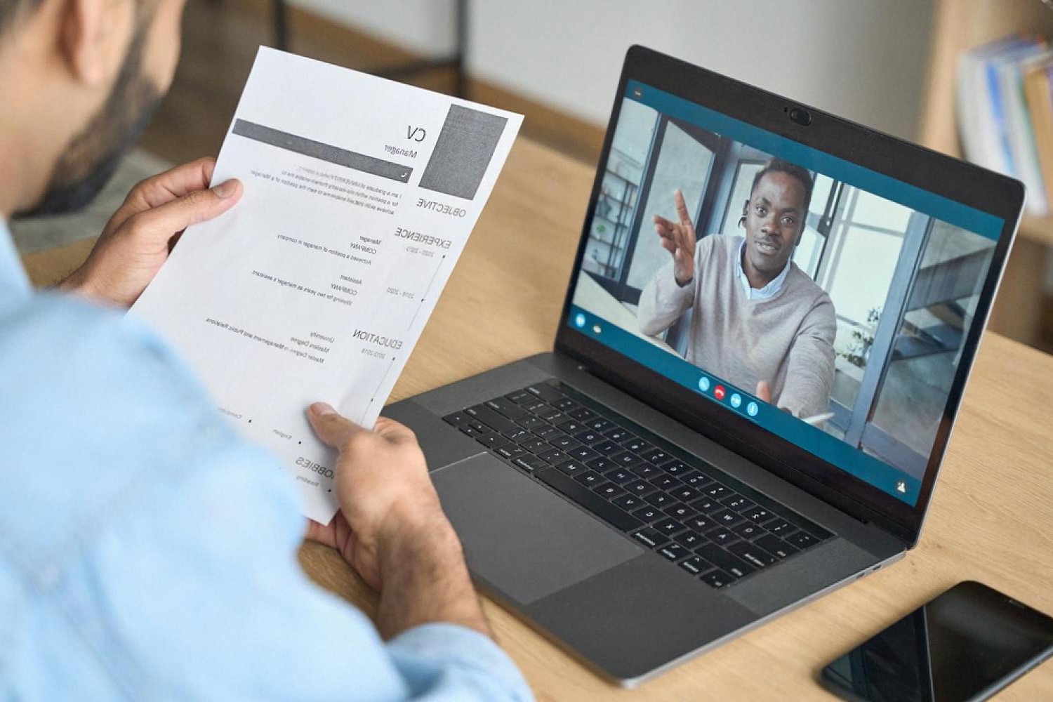 Hiring manager checking a candidate's CV during a remote employment verification call
