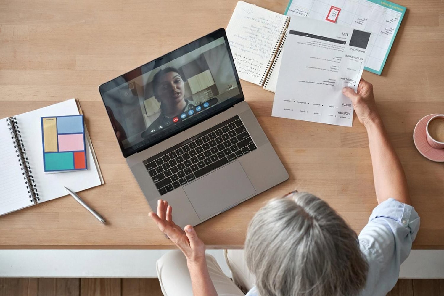 Recruiter reviewing a CV during a video interview while conducting an employment background check