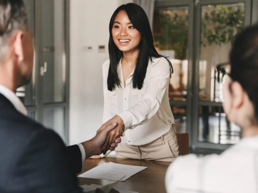 Newly hired candidate shaking hands with UAE interviewers after passing background screening